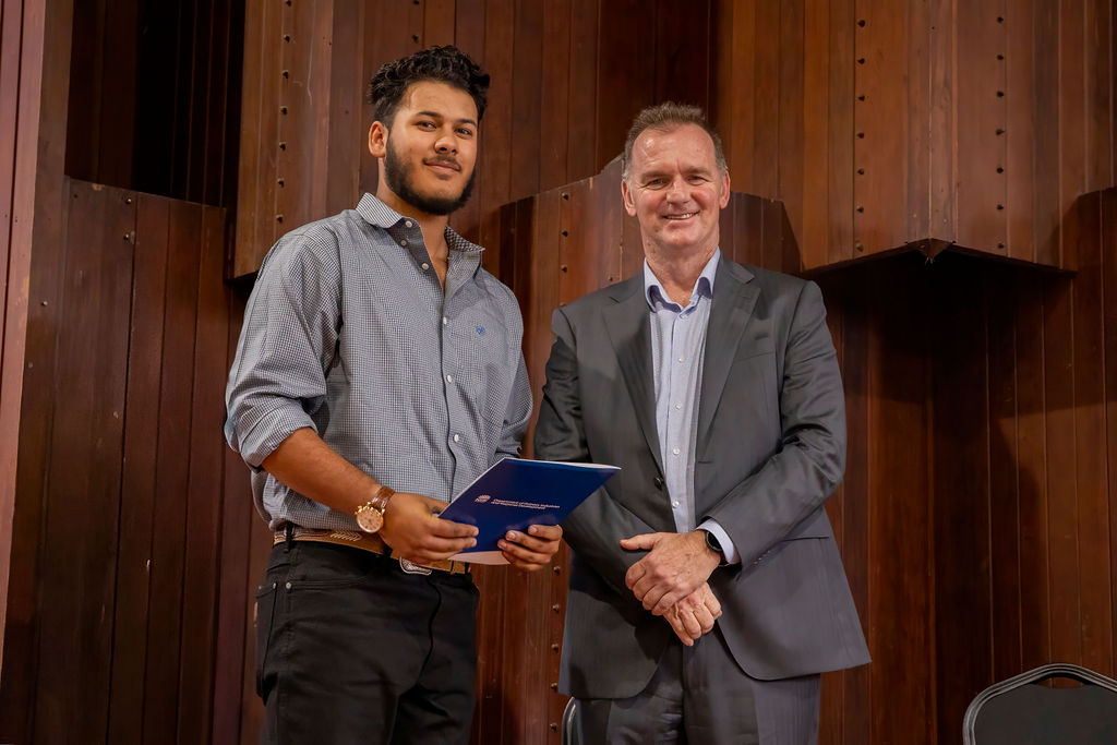 Young male graduate receiving certificate