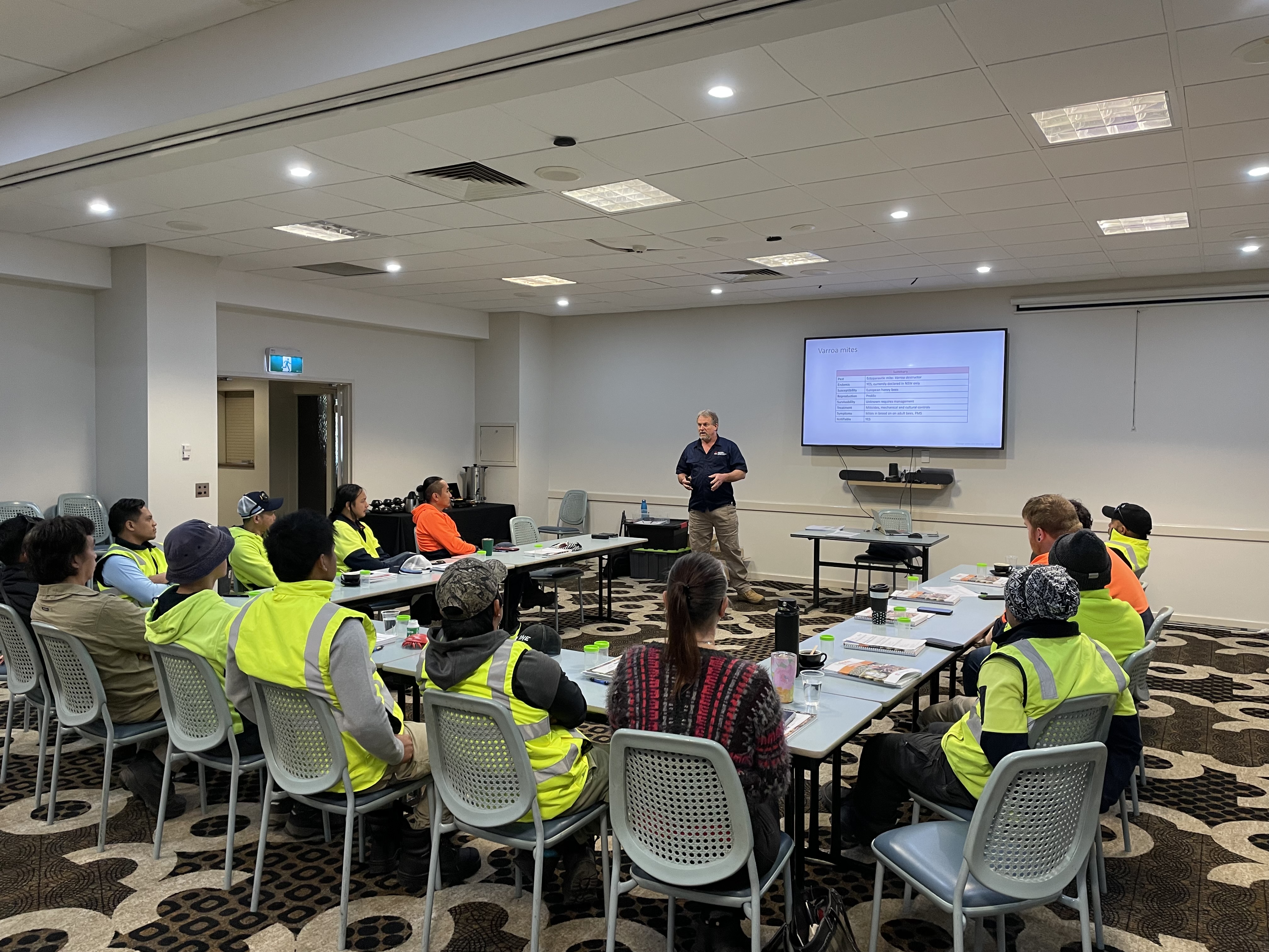 Beekeepers learning in a group in a function room