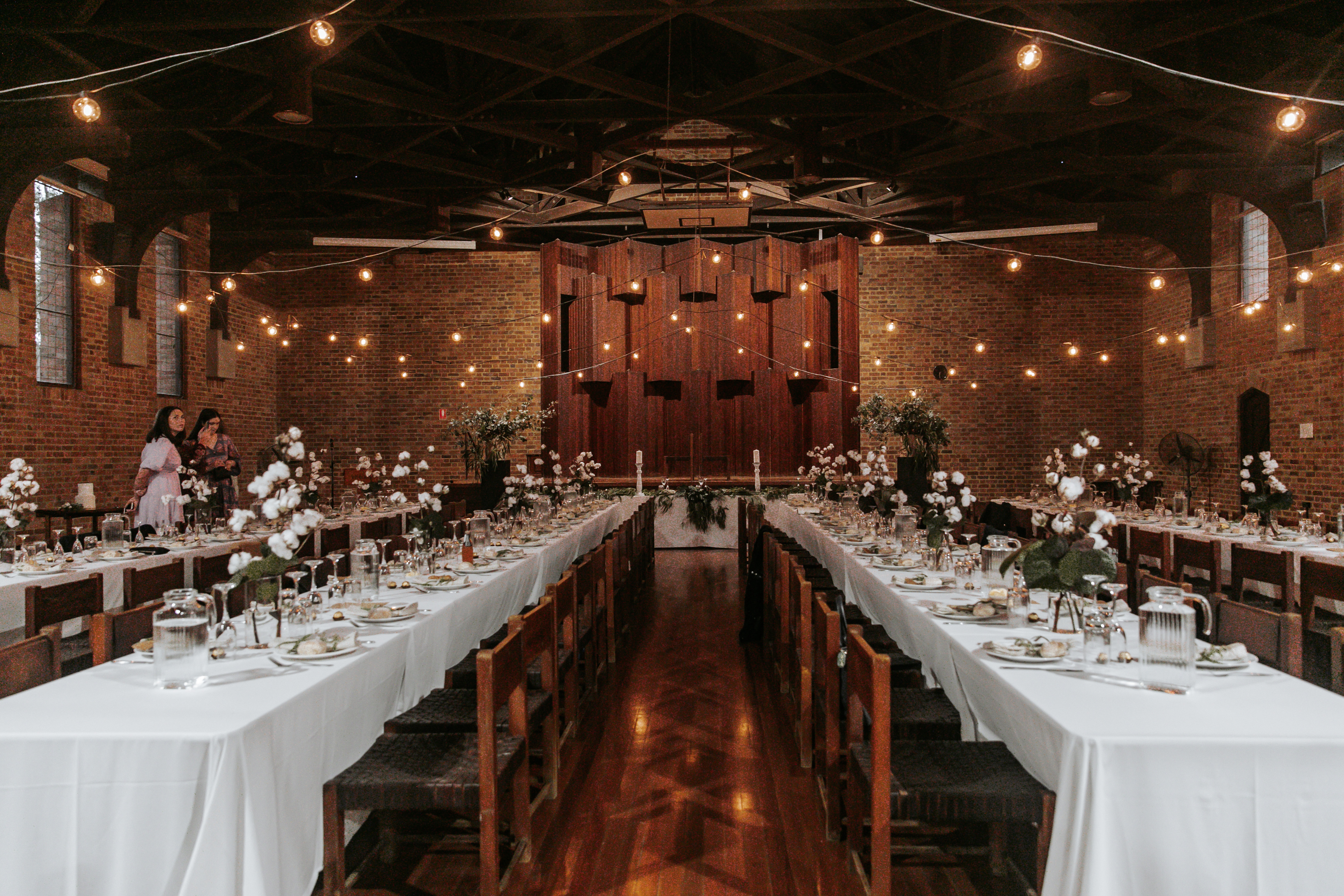 Hall set with banquet tables and garland lights